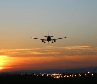 Avião a sobrevoar o pôr do sol
