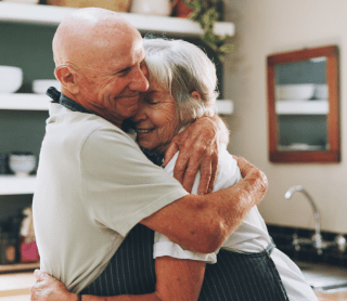 Um homem e uma mulher de idade abraçados 
