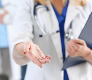 Médica com a mão esticada para a frente