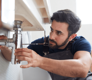 Homem a arranjar um cano