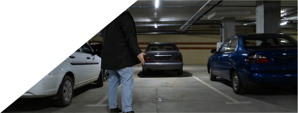 Homem na garagem a olhar para o seu carro