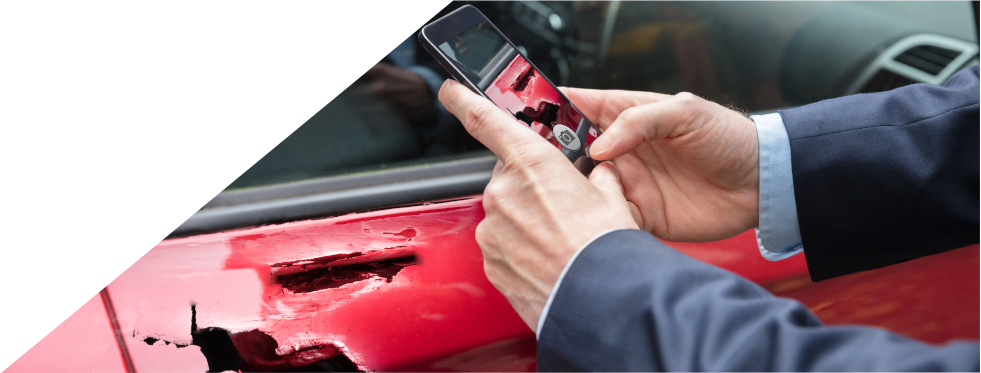 Homem a tirar fotografia ao seu carro partido