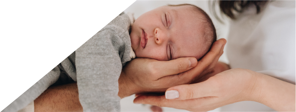 bebé a dormir nas mãos dos pais