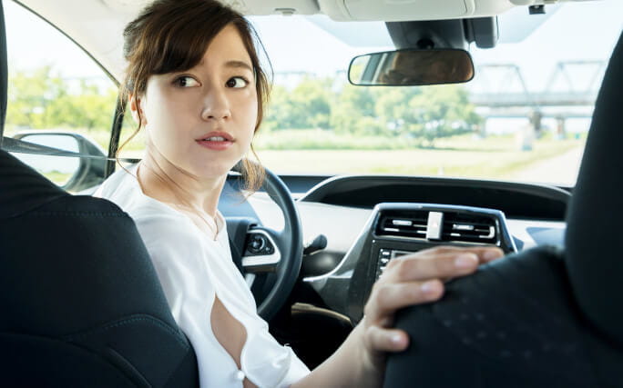 Mulher jovem a ter cuidado depois de ouvir um barulho do carro.
