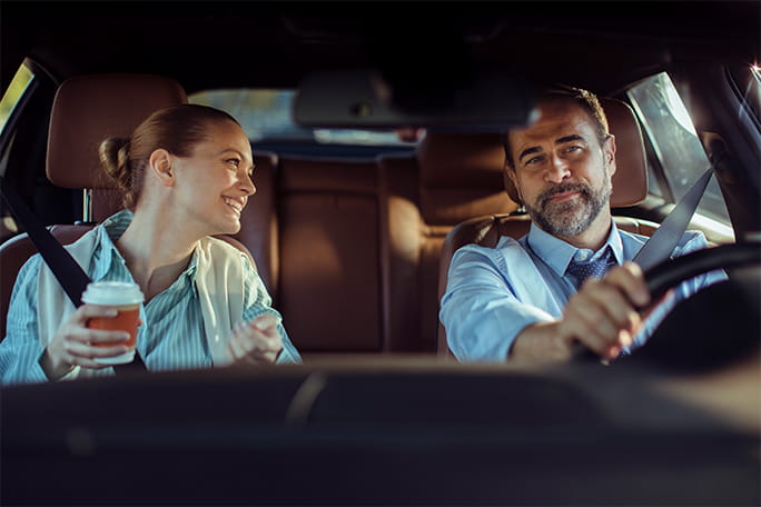 Casal feliz em viagem dentro de um automóvel