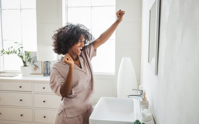 Mulher feliz por conseguir eliminar o cheiro a esgoto da casa de banho. 