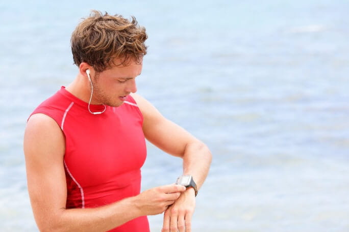 homem a mexer no relógio durante a corrida