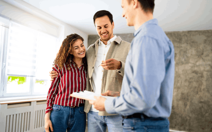 Um jovem casal muito feliz ao comprar primeira casa.