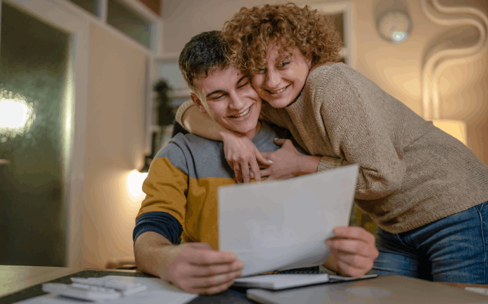 Mãe abraça o filho que acaba de saber que entrou para o primeiro ano de universidade.