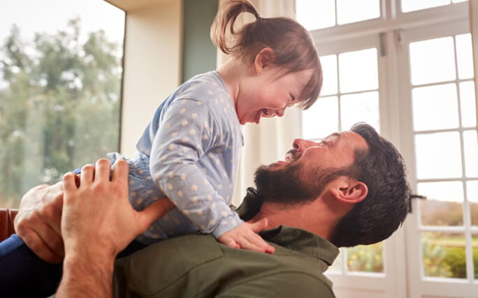 Pai abraça alegremente filha com deficiência