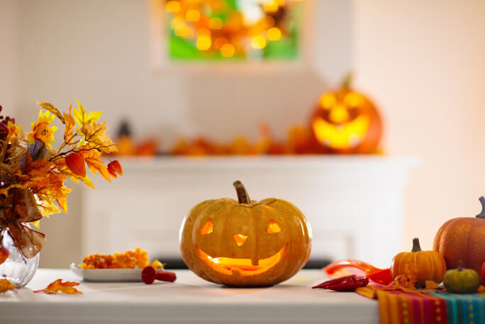 Sala decorada com abóboras escavadas e iluminadas a antecipar um Halloween feliz.