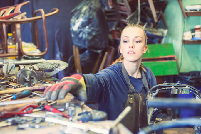 Jovem mulher trata da manutenção da moto 