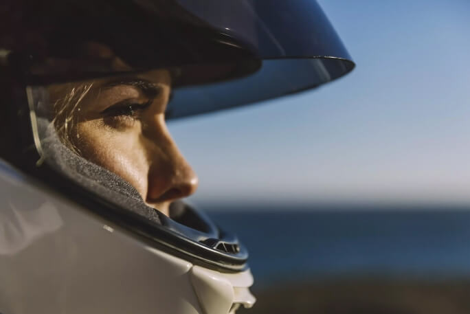 mulher com capacete de moto a conduzir