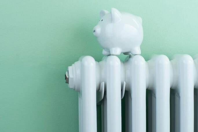 Porquinho-mealheiro em cima de um aquecedor, a simbolizar a redução do consumo de energia