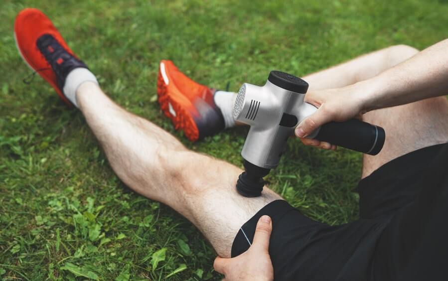 Corredor a usar massajador muscular