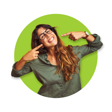 Rapariga de óculos, cabelo comprido e camisa verde, sorridente, a apontar para os próprios dentes