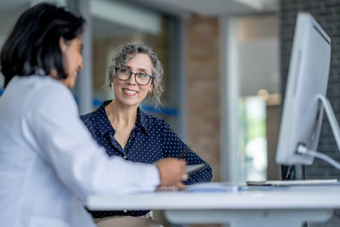 Mulher a receber orientação sobre cuidados de saúde.