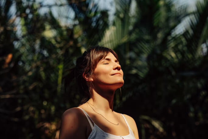 Jovem mulher faz respirações profundas para lidar com o stress.