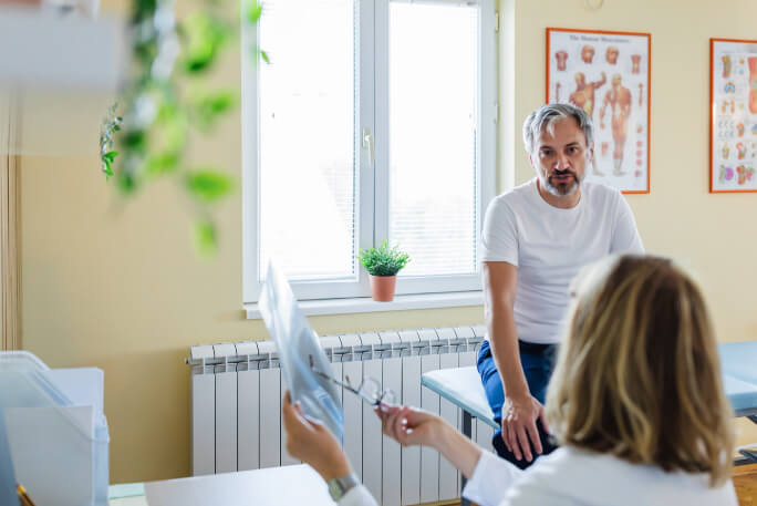 Em consulta médica, um paciente é informado sobre a prevenção do cancro.
