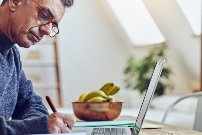 Homem numa secretária a trabalhar a um computador