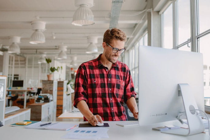 homem em pé ao computador