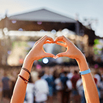 mãos a fazer um coração num festival