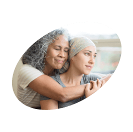 Duas mulheres abraçadas, um delas com um lenço na cabeça por ter o cabelo curto devido ao cancro.