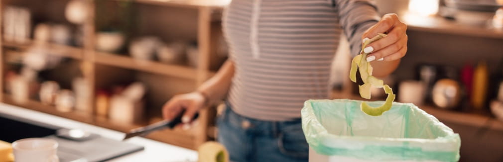 Mulher a preparar alimentos na cozinha, ilustrando o desperdício alimentar.
