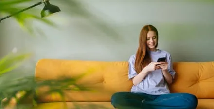 Uma rapariga jovem consulta um dicionário de seguros, no seu smartphone.