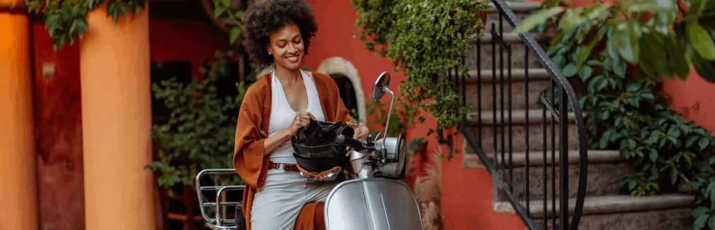 Mulher jovem feliz depois de decidir entre comprar uma moto ou scooter.