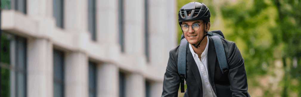 Jovem com capacete utiliza a bicicleta como meio de transporte para o trabalho