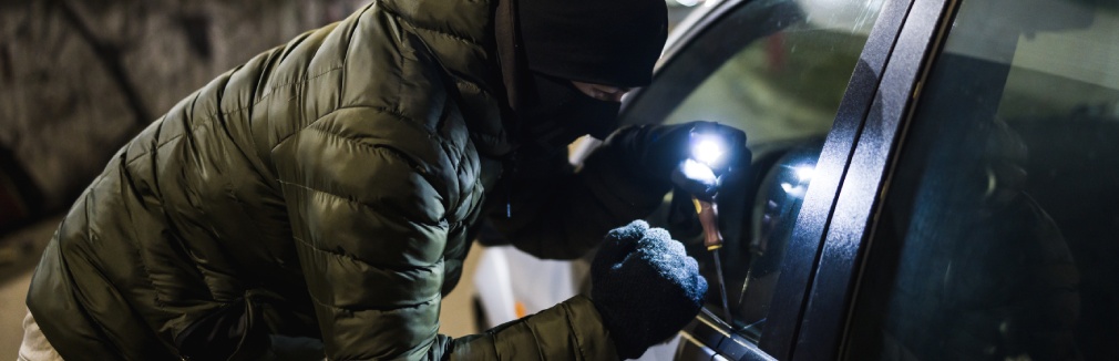 Ladrão tenta arrombar o carro com um ferro de abrir fechaduras.