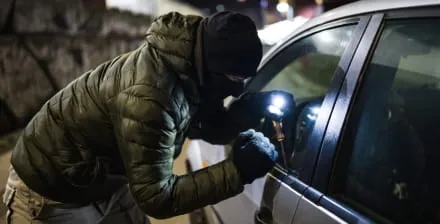 Ladrão tenta arrombar o carro com um ferro de abrir fechaduras.