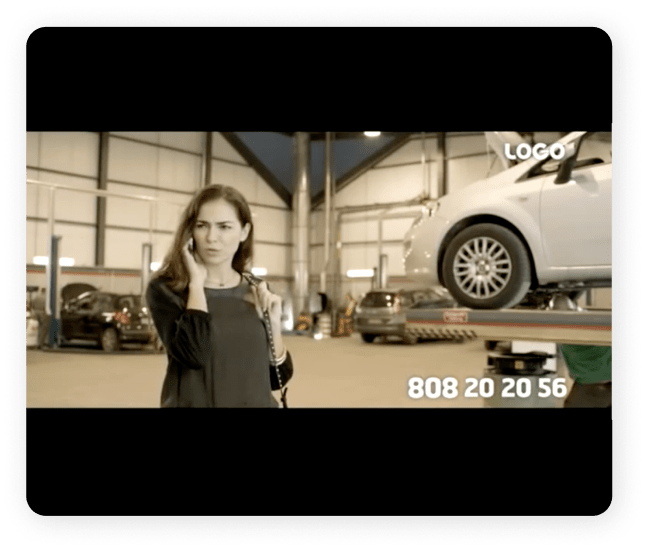 Mulher jovem, ao telemóvel, numa oficina