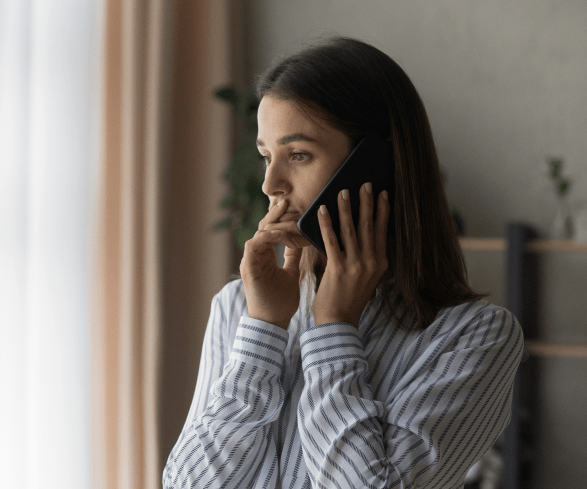 Mulher ao telefone com ar preocupado.