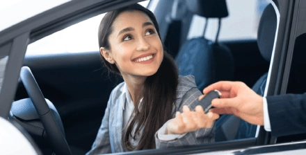 Mulher jovem prepara-se para conduzir um carro emprestado.